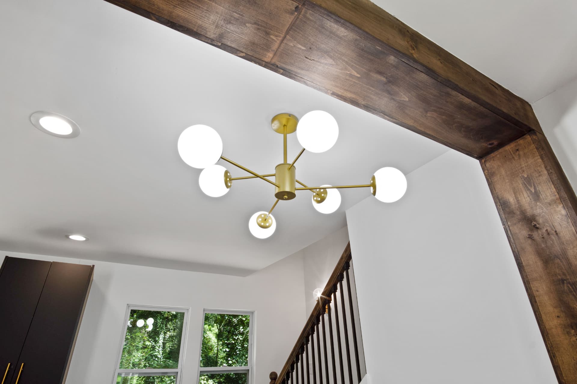 Brass globe chandelier beneath the exposed wood beam