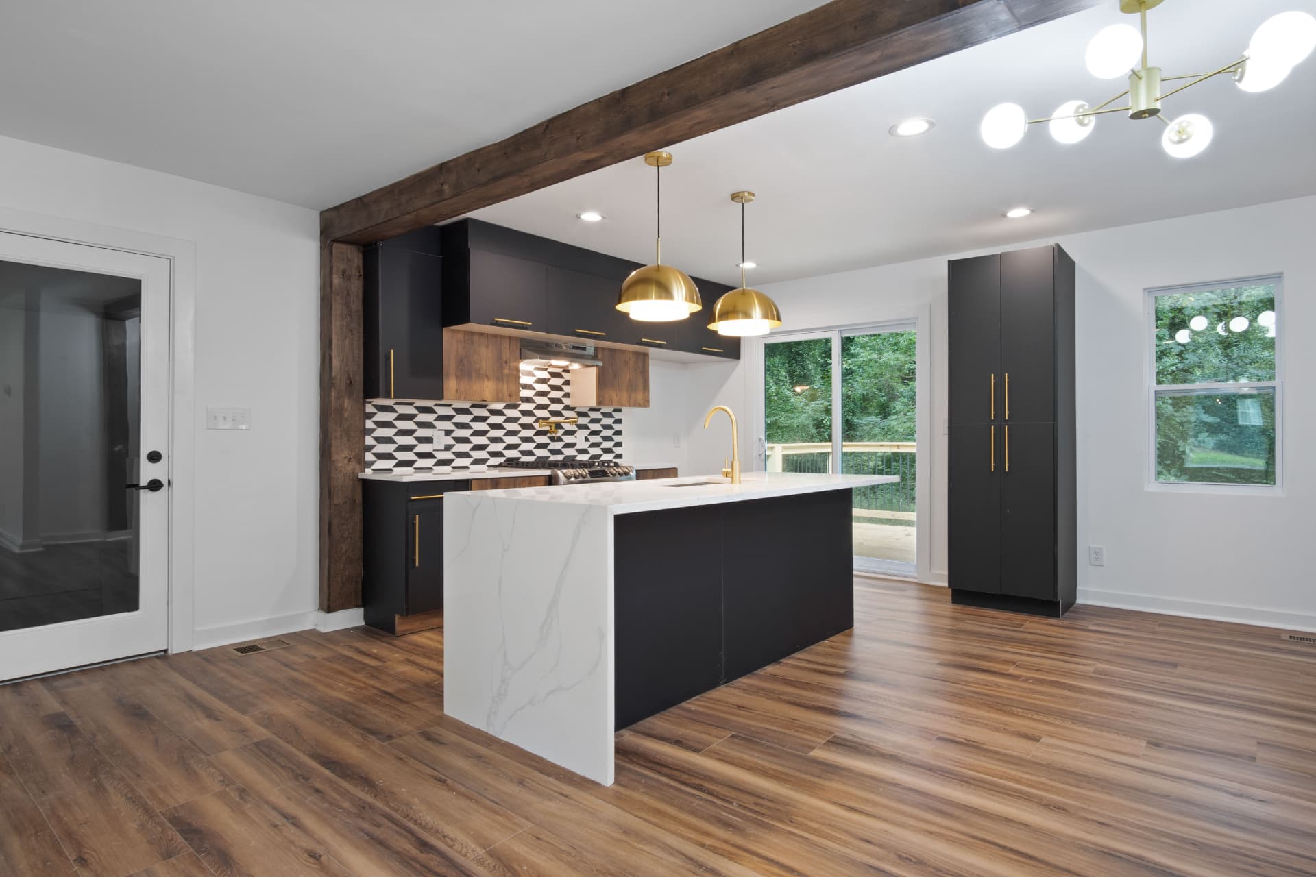 Kitchen with waterfall quartz island and brass pendants