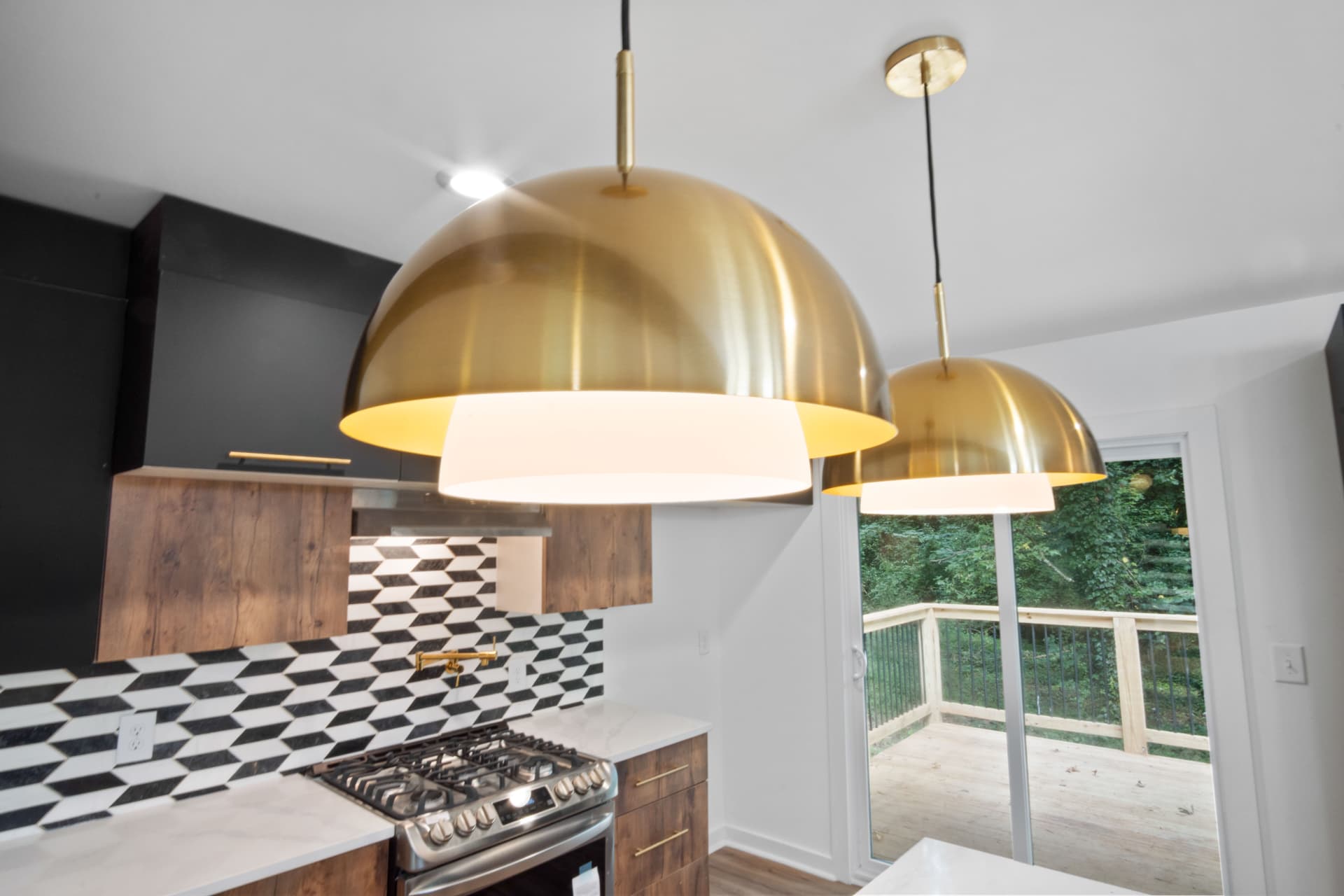 Brass dome pendant lights above the range
