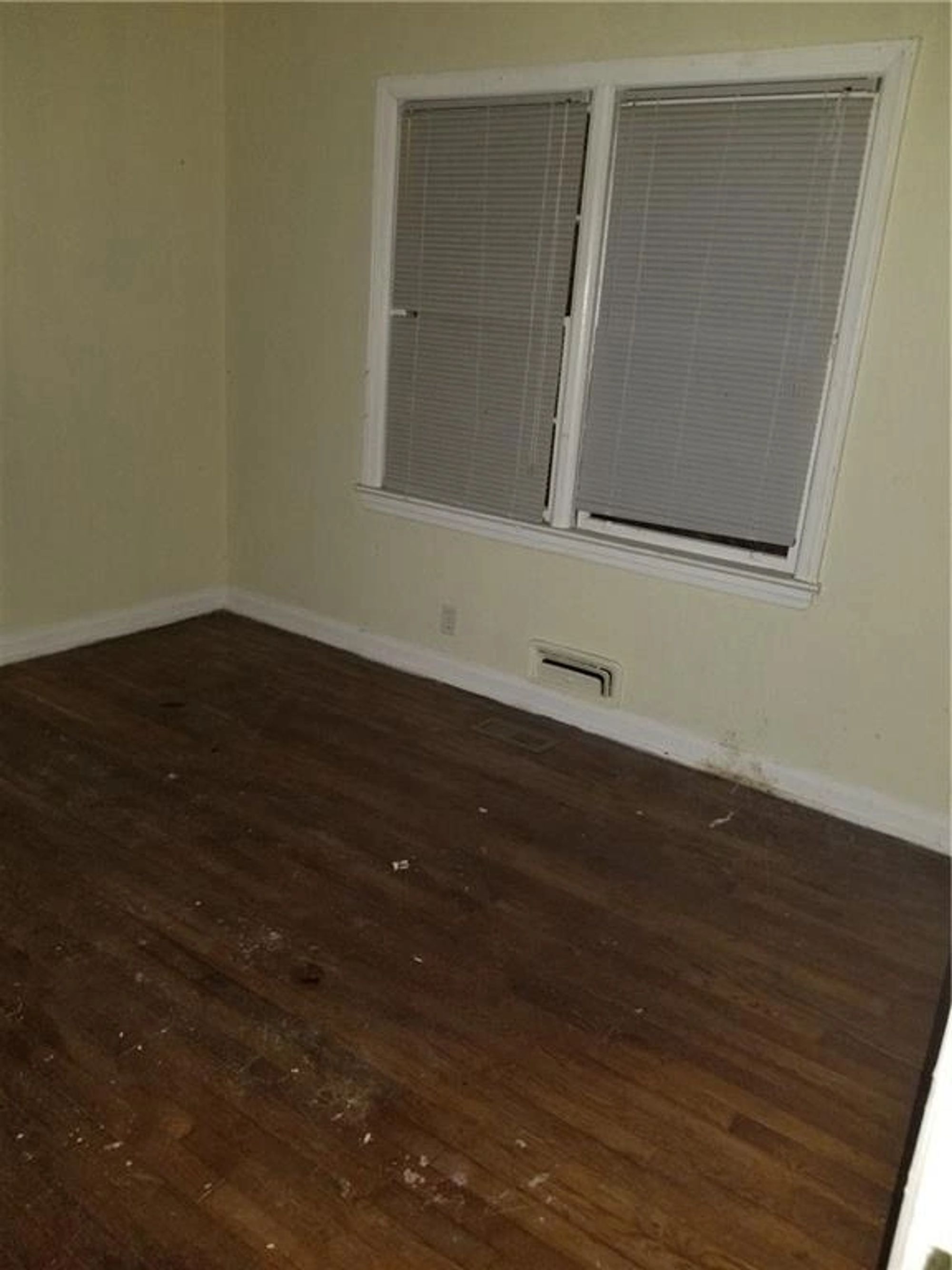 Original bedroom with worn hardwood flooring