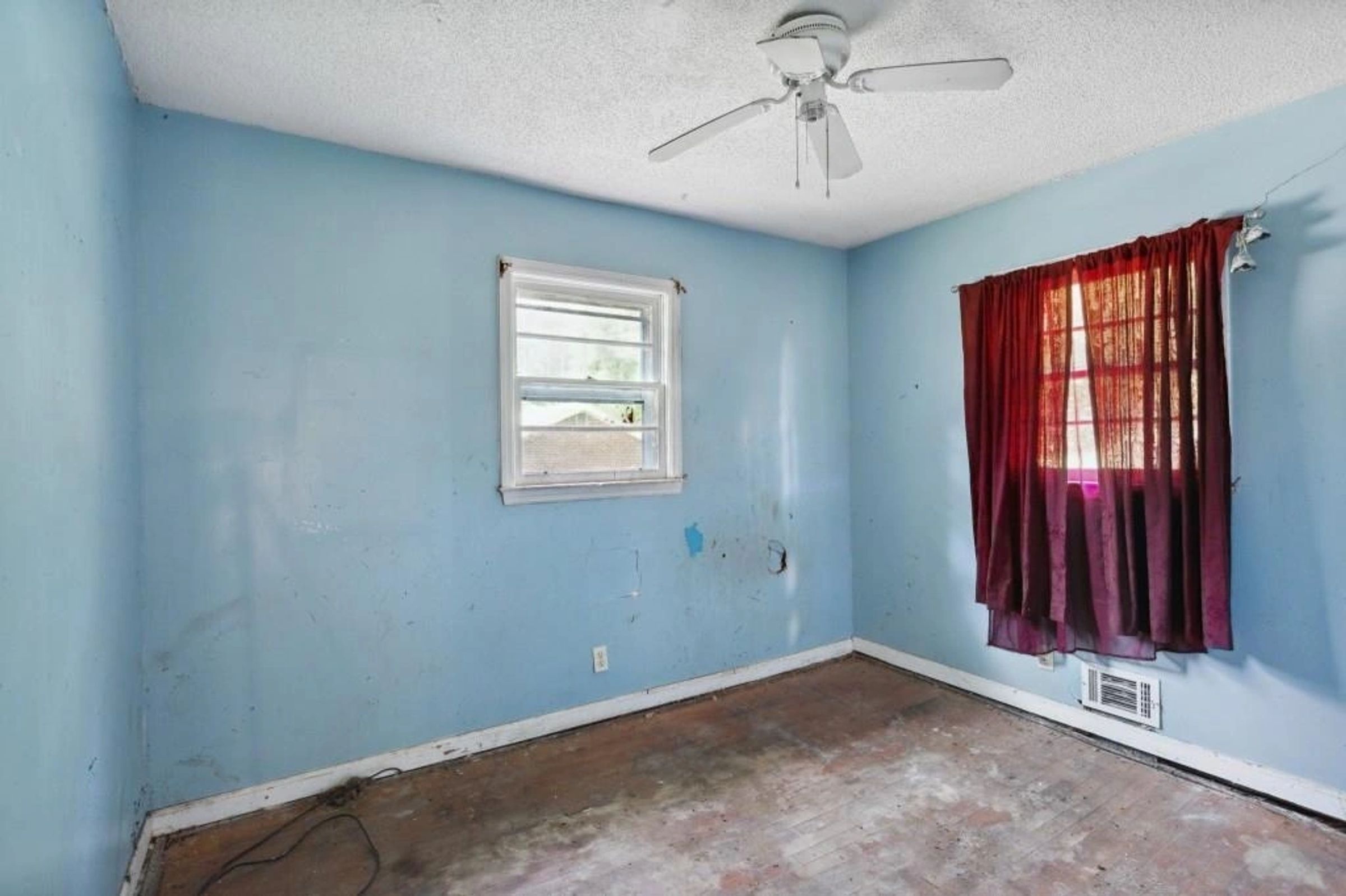 Original bedroom with window and worn flooring
