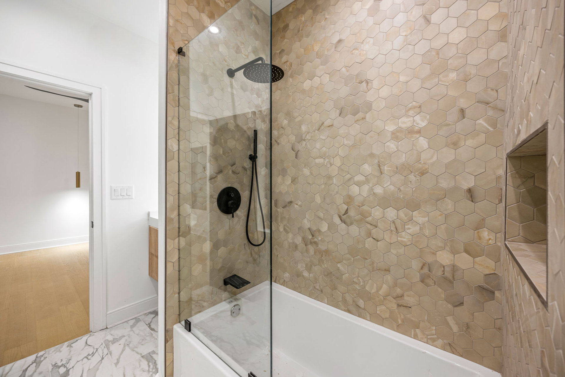 Tub-shower with onyx hexagon tile and matte black fixtures