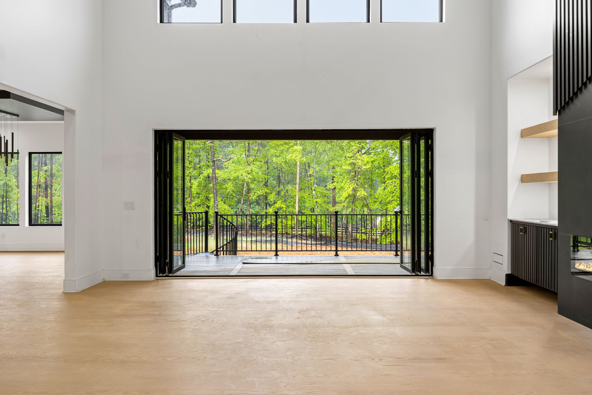 Great room with folding glass doors opening to a wooded deck