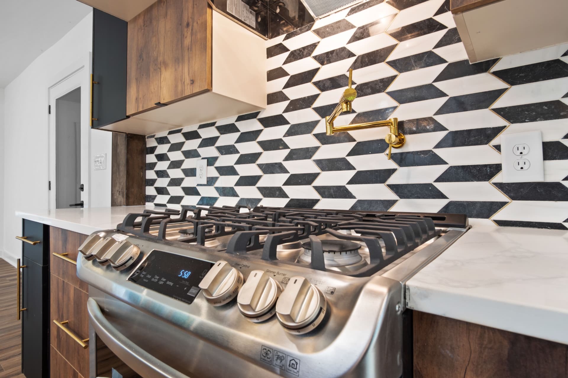 Gas range with pot filler and geometric marble backsplash