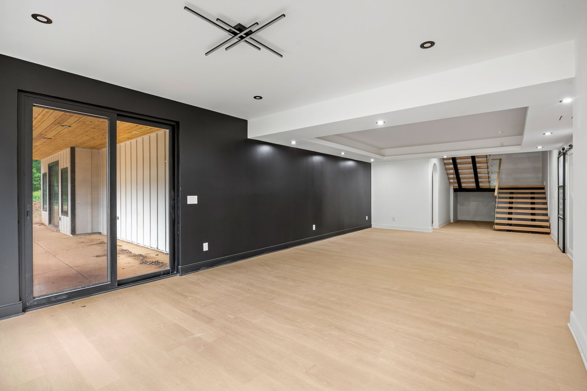 Lower level living area with black accent wall and open stair