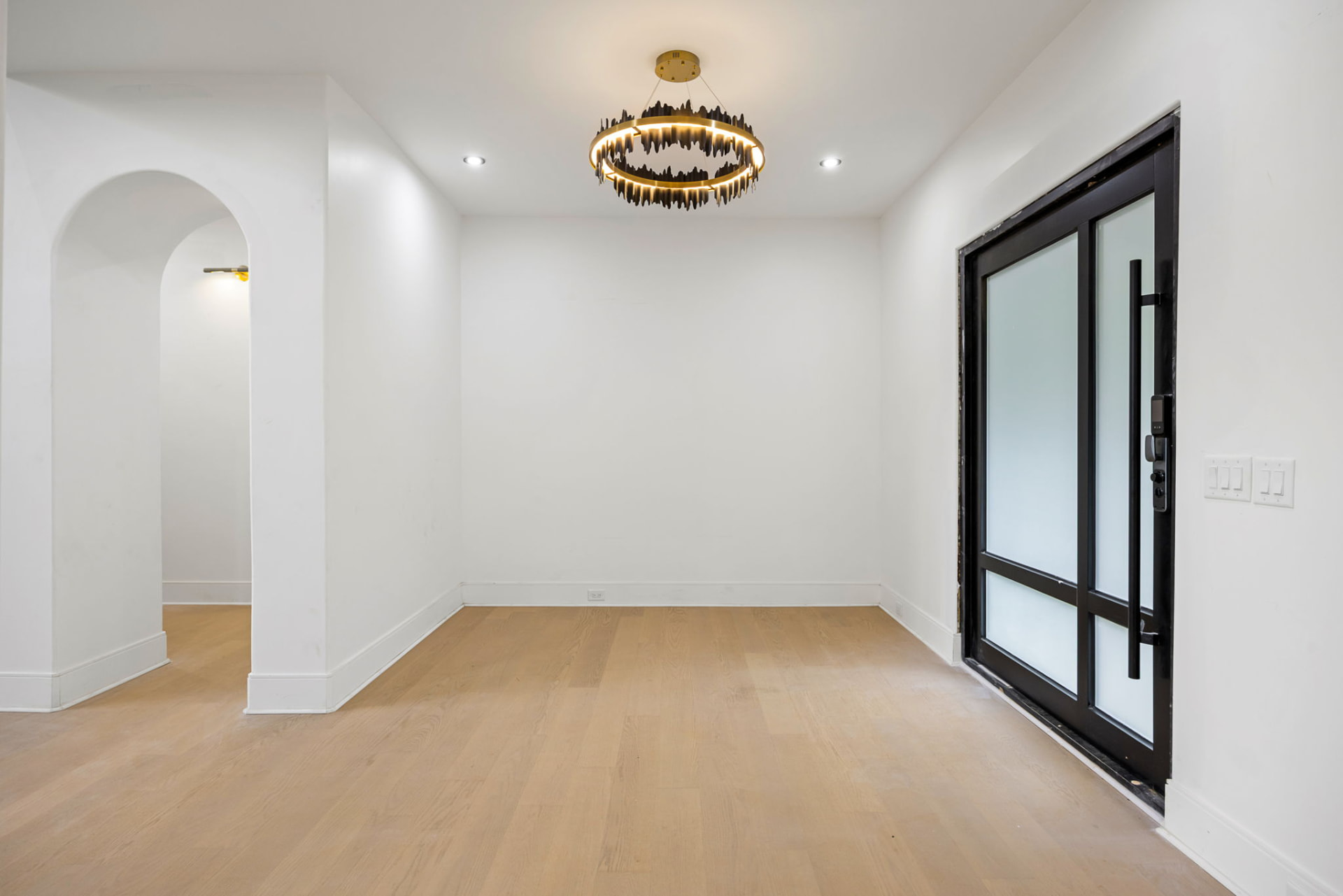 Entry foyer with brass ring chandelier and frosted glass front door