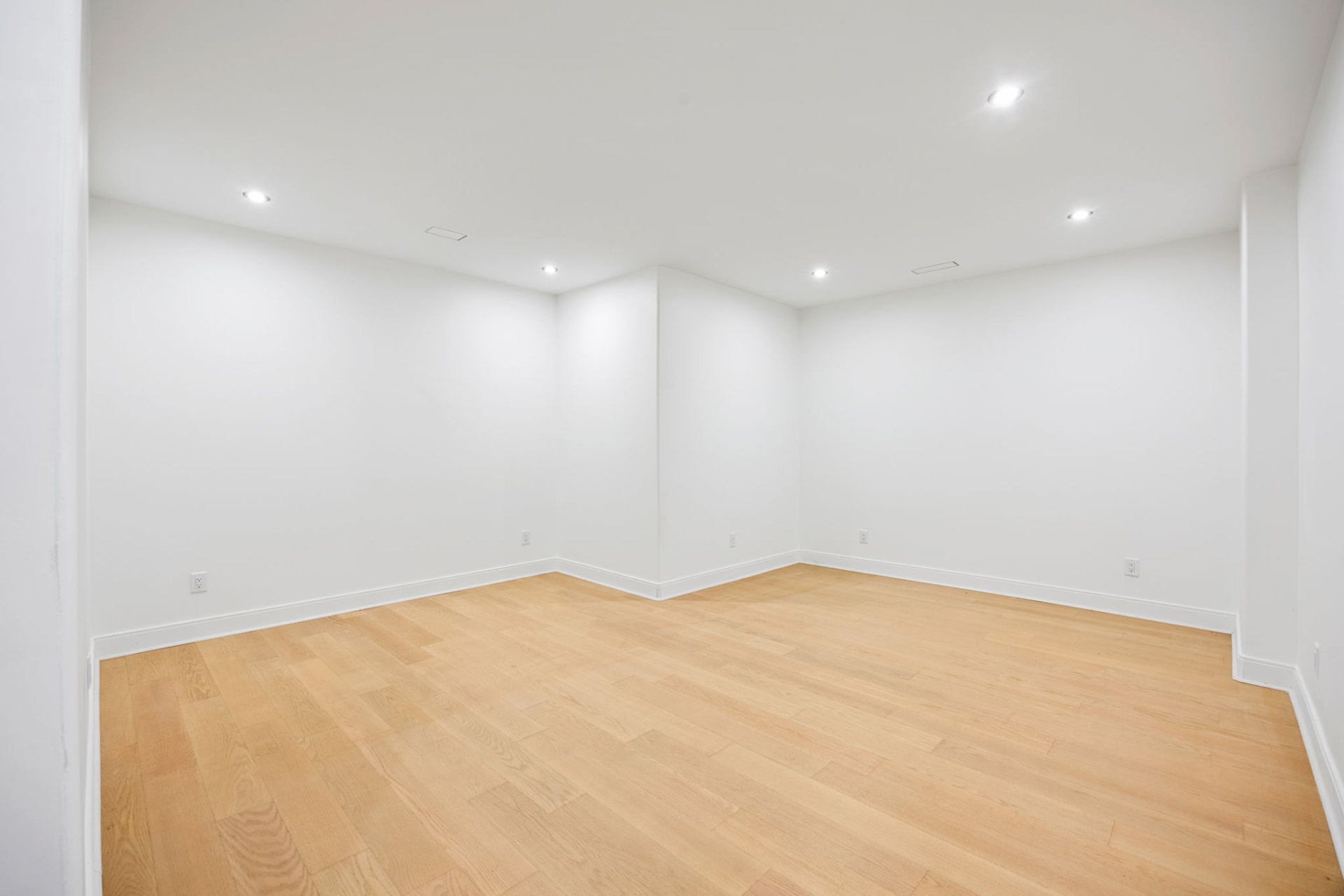 Lower level bedroom with white oak floors and recessed lighting