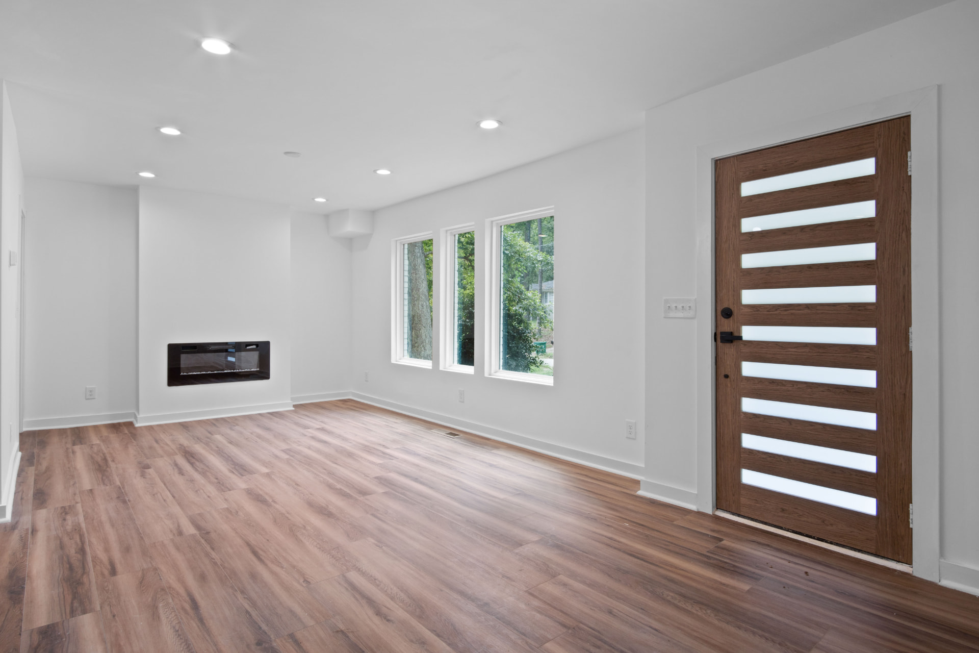 Living room with linear fireplace and modern front door